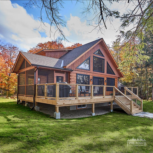 Arrowhead two-storey Canadian log home by True North Log Homes with cathedral ceilings and floor-to-ceiling windows - Front Aspect